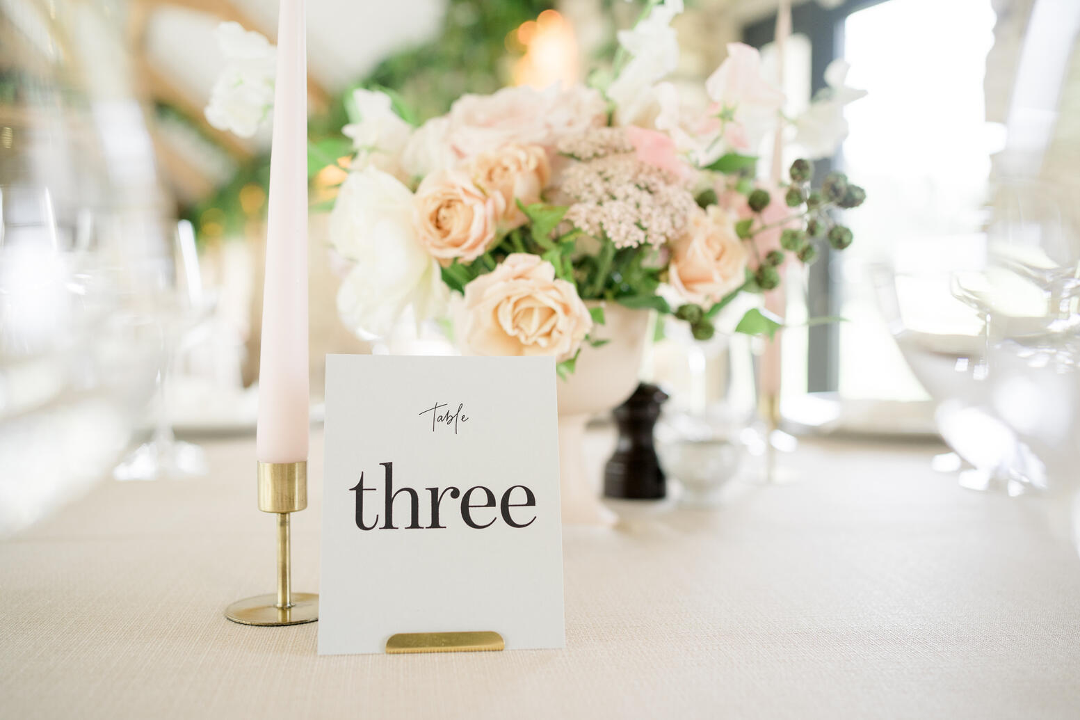 Table number and pink dinner candle in a brass holder Table number and pink dinner candle in a brass holder