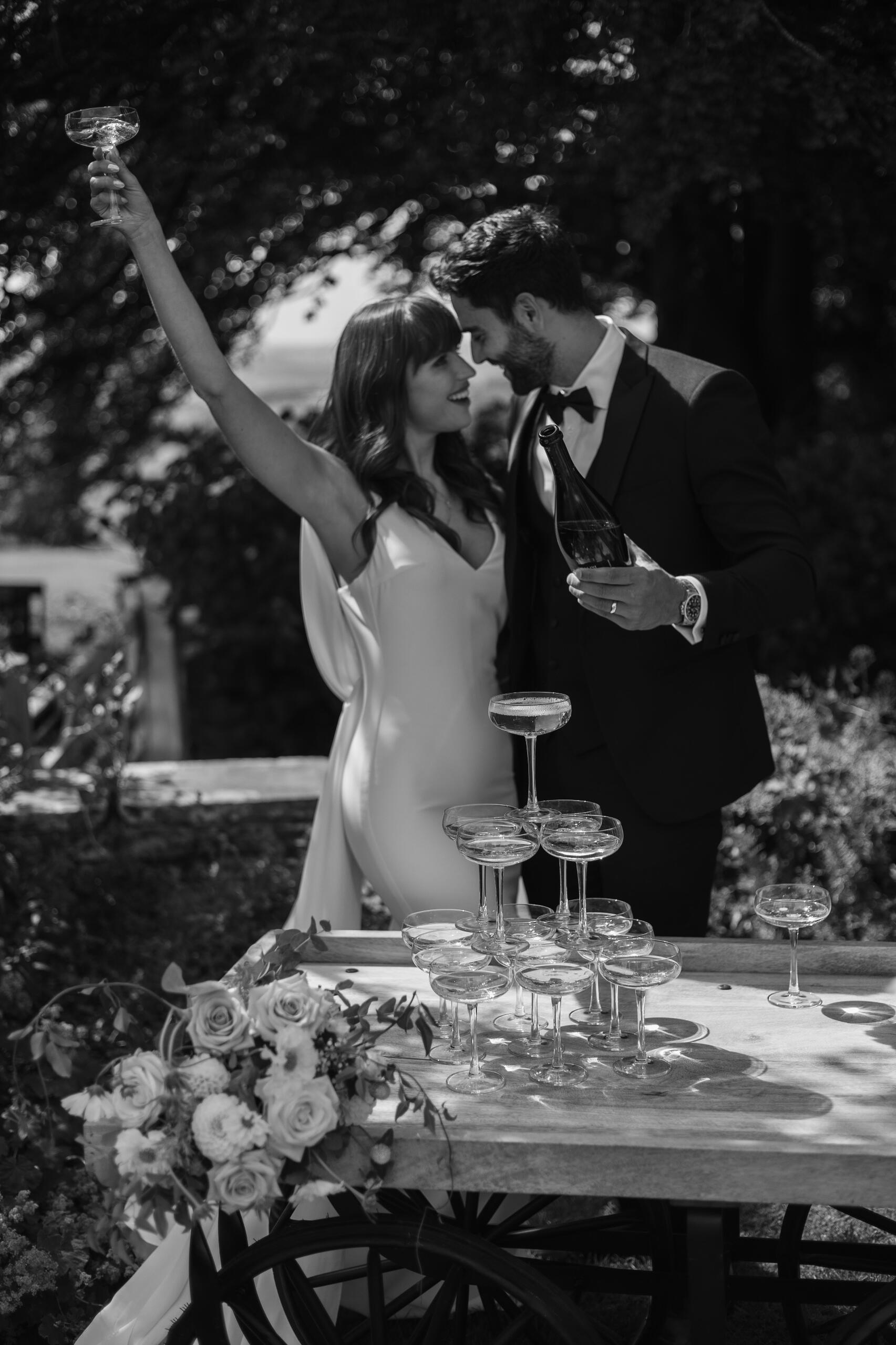 Groom kissing brides hand with countryside in background